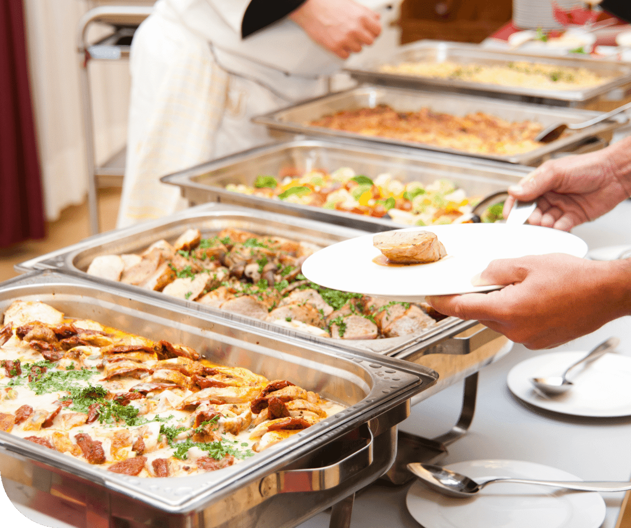 Person choosing food from buffet table